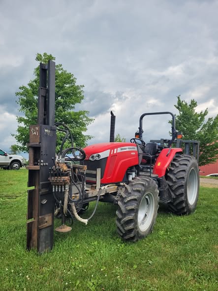 Tractor-mounted post driver used for setting fence line posts
